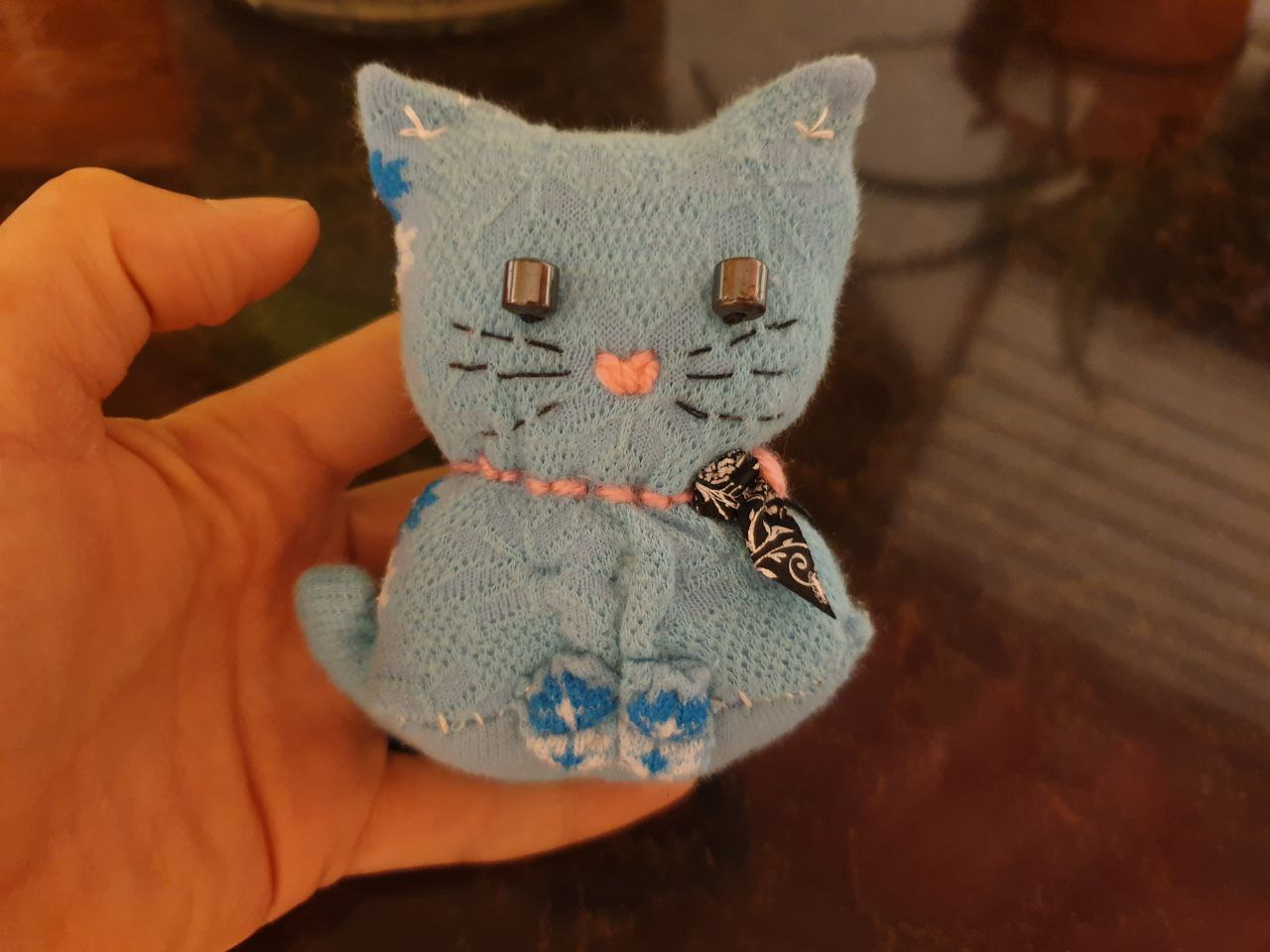 A hand holding a small stuffed animal Description automatically generated with low confidence