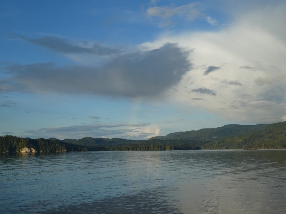 A body of water with hills in the background Description automatically generated with medium confidence